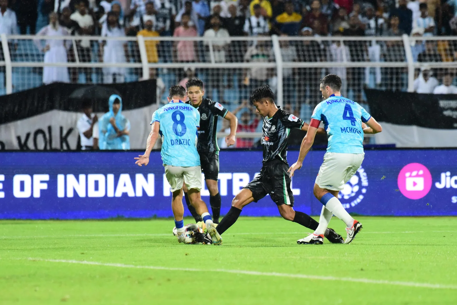 Indian Super League football players competing on a rain-soaked pitch